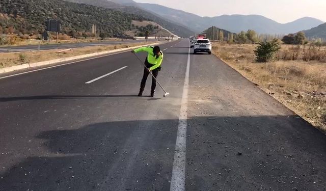 Trafik polisi cam kırıkları ve taş dökülen yolu fırçayla temizledi